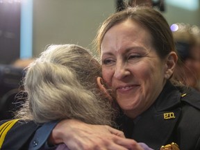 Stacey Graves, right hugs colleagues after she was selected by the Kansas City Board of Police Commissioners to serve as the next chief of police for the Kansas City Police Department, Thursday, Dec. 15, 2022, in Kansas City, Mo.