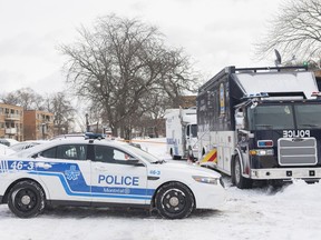 Police vehicles are shown outside an apartment building where two people were found dead in Montreal,Tuesday, December 27, 2022. Montreal police say a man and woman have died in the city's east end after what's believed to be a murder-suicide.