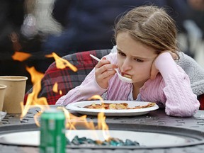 Eden Maracco, 8, has lunch with her family while power is out at her home, at Reds Food Truck Corner in Southern Pines, N.C., Monday, Dec. 5, 2022. Tens of thousands of people braced for days without electricity in a North Carolina county where authorities say two power substations were shot up by one or more people with apparent criminal intent.