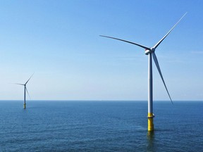 FILE - Two of the offshore wind turbines, which have been constructed off the coast of Virginia Beach, Va., are seen, June 29, 2020. Virginia regulators granted a critical approval Thursday, Dec. 15, 2022, for Dominion Energy's plans to construct and operate a 176-turbine wind farm in the Atlantic Ocean.