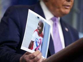 FILE- Then-President Donald Trump holds a photo of LeGend Taliferro as he speaks at a news conference in the James Brady Press Briefing Room at the White House, on Aug. 13, 2020, in Washington. Ryson Ellis, 24, of Kansas City, was sentenced to 22 years in prison after pleading guilty Friday, Dec. 2, 2022, to second-degree murder, unlawful use of a weapon and armed criminal action in the killing of a LeGend Taliferro, 4-year-old Kansas City boy whose death led to a federal operation meant to reduce violent crime in 2020.