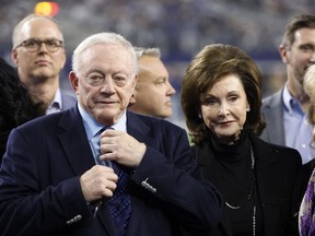 FILE -Dallas Cowboys owner Jerry Jones and his wife Gene Jones, right, on the field during an NFL Football game in Arlington, Texas, Sunday, Dec. 4, 2022. A judge has ordered Dallas Cowboys owner Jerry Jones to take a paternity test as part of a legal dispute with a 26-year-old woman who claims the billionaire is her biological father. A Texas judge issued the order for genetic testing Thursday, Dec. 22, 2022 in a paternity case brought by Alexandra Davis.