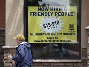 FILE - Starting wages are advertised on a sign in the window of a Taco Bell in Sacramento, Calif., Monday, May 9, 2022. A wave of retirements, a drop in legal immigration, and hundreds of thousands of COVID-19 deaths have left the U.S. with a smaller workforce than when the pandemic began two and half years ago, a change that could bolster wage growth and inflation and force the Federal Reserve to keep interest rates higher for longer.