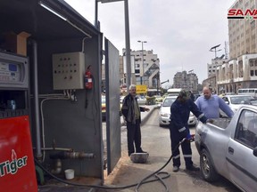 FILE - This file photo released on April 7, 2019, by the Syrian official news agency SANA, shows a worker filling a pickup at a gas station, in Homs, Syria. The Syrian government has decided to close state agencies for two days due to severe fuel shortages caused by disruption of supplies arrivals and Western sanctions imposed on President Bashar Assad's government. Syrian state media reported Tuesday, Dec. 6, 2022 that the decision to close the institutions on Sunday Dec. 11 and 18, come at a time when many employees have been unable to make it to work because public transport has been badly affected by the crisis.