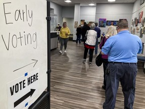 FILE - People wait in line to early vote for the U.S. Senate runoff election in Georgia between Sen. Raphael Warnock and challenger Herschel Walker, on Monday, Nov. 28, 2022, in Kennesaw, Ga., near Atlanta. Nonprofit organizations in Georgia are digging deep to ramp up their operations again after Election Day to inform voters about the closely watched runoff race for one of the state's Senate seats.