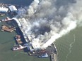 Firefighters battle a blaze at a warehouse in the Brooklyn Borough of New York on Tuesday, Dec. 13, 2022 in New York. Eight people suffered minor injuries in the fire at a New York Police Department warehouse that houses DNA evidence from crime scenes as well as cars, e-bikes and motor scooters, police and fire officials said. (WABC via AP)