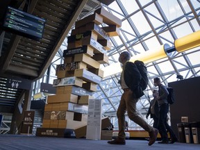 Delegates walk past a giant Jenga-style tower at the COP15 United Nations conference on biodiversity in Montreal, Thursday, Dec. 8, 2022. The tower illustrates the complex web of life where each brick nudged out of place represents damage caused to nature and with it the danger of ecosystem collapse.