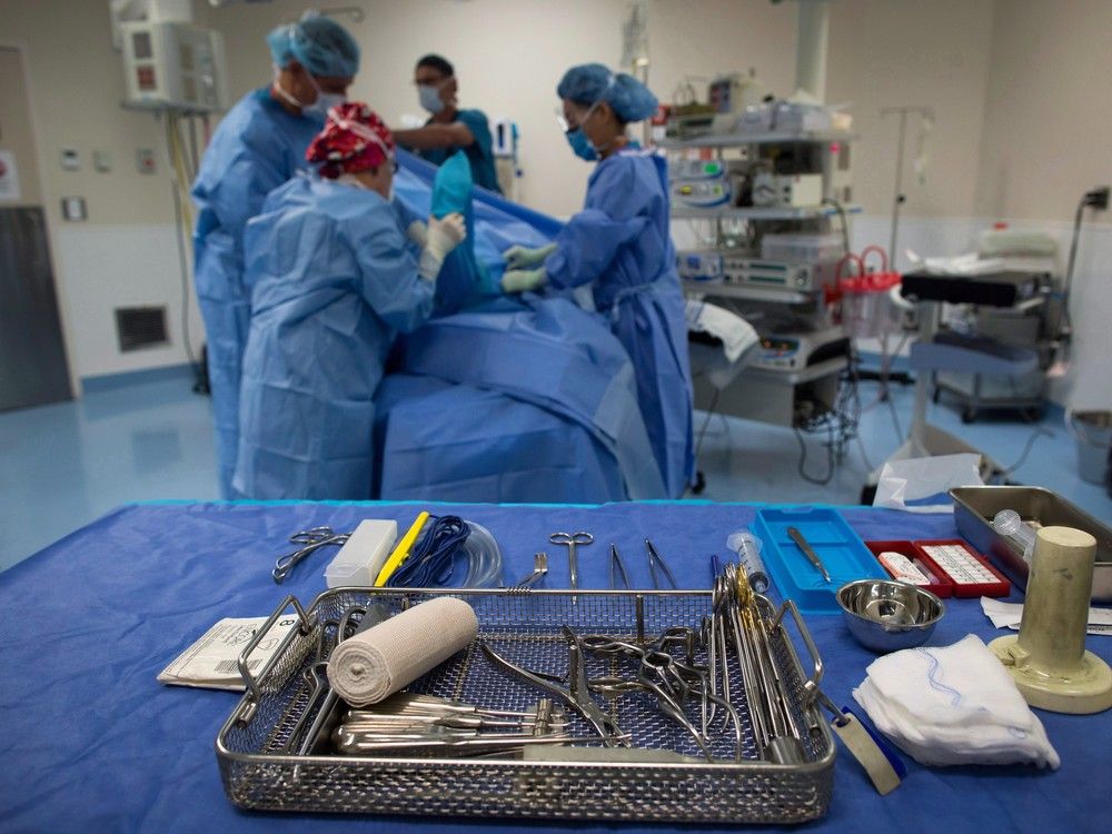 Sterile instruments are laid out as a male patient is prepared to have a cyst removed from his right knee at the Cambie Surgery Centre, in Vancouver.