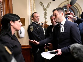 Parti Québécois Leader Paul St-Pierre Plamondon, centre, speaks to Sergeant-At-Arms Véronique Michel, who prevented the three PQ MNAs from entering the National Assembly on December 1, 2022. The three MNAs have refused to swear an oath to King Charles.