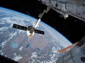 The Canadarm 2 reaches out to capture the SpaceX Dragon cargo spacecraft and prepare it to be pulled into its port on the International Space Station, Friday, April 17, 2015. THE CANADIAN PRESS/AP/NASA