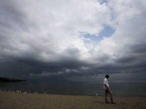 A person looks out over Lake Ontario as a thunderstorm rolls through Toronto on Thursday, August 4, 2022.