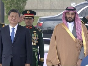 In this image taken from footage by Saudi State TV, Chinese President Xi Jinping, left, listens to the Chinese national anthem next to Saudi Crown Prince and Prime Minister Mohammed bin Salman in Riyadh, Saudi Arabia, Thursday, Dec. 8, 2022.