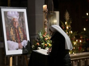 A person signs a book of condolence for Pope Emeritus Benedict XVI at the Saint Magdalena church in Altoetting, Germany, Saturday, Dec. 31, 2022. Pope Emeritus Benedict XVI, the German theologian who will be remembered as the first pope in 600 years to resign, has died, the Vatican announced Saturday. He was 95.