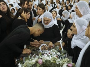 FILE - Members of the Israeli Druze minority mourn around the body of Tiran Fero, 17, during his funeral in Daliyat al-Carmel, Israel, on Nov. 24, 2022. Israel's military says its prosecutor has filed indictments against two soldiers who allegedly hurled an explosive device at a Palestinian home in the occupied West Bank last month. The indictment announced Thursday, Dec. 29, said the two soldiers acted out of revenge for the kidnapping of the body of an Israeli schoolboy in the flashpoint West Bank city of Jenin on Nov. 22.