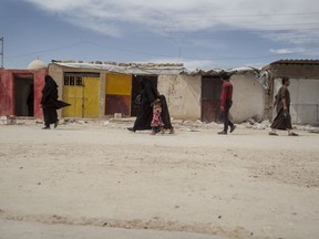 People walk in the marketplace at al-Hol camp that houses some 60,000 refugees, including families and supporters of the Islamic State group, many of them foreign nationals, in Hasakeh province, Syria, Saturday, May 1, 2021.THE CANADIAN PRESS/AP-Baderkhan Ahmad