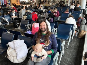 Michael Worthman and his infant daughter in Toronto's Pearson airport on Thursday, December 22 as they wait to get on a standby flight. Worthman and his family are attempting to get to Newfoundland but missed their earlier connection.