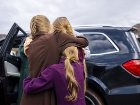 FILE - Three girls embrace before they are removed from the home of Samuel Bateman, following his arrest in Colorado City, Ariz., on Wednesday, Sept. 14, 2022. Federal documents released Friday, Dec. 2 show that Bateman, the leader of a small polygamous group near the Arizona-Utah border, had taken at least 20 wives, most of whom were minors, and punished followers who did not treat him as a prophet.