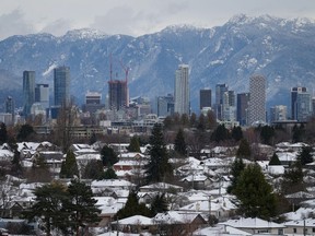 Snow-covered houses and the downtown skyline are seen after a snowstorm, in Vancouver, B.C., Wednesday, Nov. 30, 2022. A high pressure system over British Columbia is pushing arctic air and bitter cold to several areas of B.C. along with the potential for snow and wind on Friday.