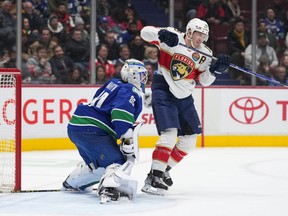 Florida Panthers' Matthew Tkachuk, right, deflects the puck wide of the net behind Vancouver Canucks goalie Spencer Martin (30) during the second period of an NHL hockey game in Vancouver, on Thursday, December 1, 2022.