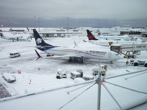 Aircraft are seen parked at gates at Vancouver International Airport after a snowstorm impaired operations leading to cancellations and major delays, in Richmond, B.C., on Tuesday, December 20, 2022.