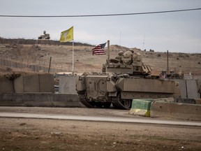 FILE - American soldiers patrol near prison that was attacked on Jan. 20 by the Islamic State militants in Hassakeh, Syria, Feb. 8, 2022. U.S. forces have stopped joint military patrols in northern Syria to counter Islamic State extremists, as Turkish threats of a ground invasion stymie those missions with Kurdish forces.