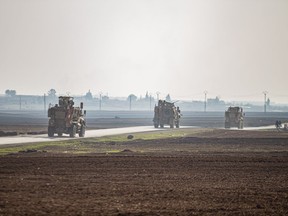 FILE - US military vehicles on a patrol in the countryside near the town of Qamishli, Syria, Sunday, Dec. 4, 2022. U.S. and Kurdish-led forces had arrested an Islamic State group militant in eastern Syria. The Kurdish-led Syrian Democratic Forces said in a statement Monday, Dec. 19, 2022 that they raided the home of an unnamed IS militant leader in the western countryside of Deir el-Zour and arrested him.