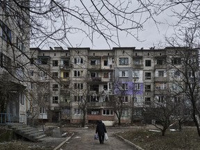 A civilian walks among heavily damaged residential buildings in Soledar, Donetsk region, Ukraine, Wednesday, Dec. 21, 2022.