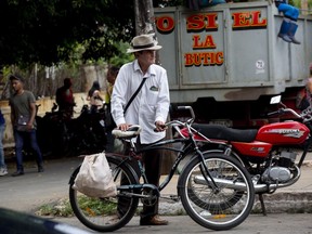 A shopper leaves the 17 and K Market on his bike in Havana, Cuba, Friday, Dec. 23, 2022. In October, the Cuban government reported that inflation had risen 40% over the past year and had a significant impact on the purchasing power for many on the island.
