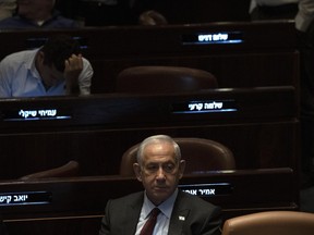 Israeli Prime Minister designate Benjamin Netanyahu, center, pauses during a session after Yariv Levin was selected as Speaker of the Knesset, Israel's parliament, in Jerusalem, Tuesday, Dec. 13, 2022.