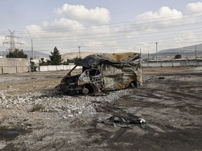 A destroyed vehicle after protesters from a nearby Roma settlement unrest overnight in Aspropyrgos, Greece, Thursday, Dec 8, 2022, following the police shooting of a Roma teenager during a police chase. Protesters in the industrial eastern Athens neighbourhood of Aspropyrgos allegedly torched a local tire business and a bus and set up burning barricades in the streets.