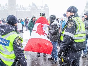 A group marks the one-year anniversary of the Freedom Convoy protest in Ottawa on Jan. 29, 2023.