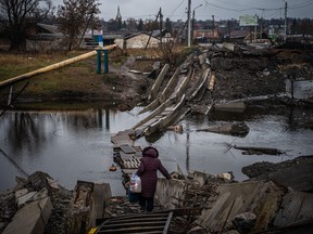 A woman crosses a destroyed bridge in Bakhmut, Donetsk region, on Jan. 6.