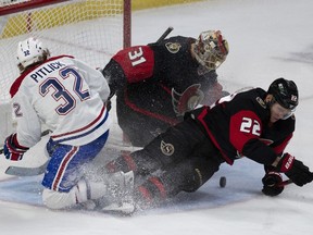 Ottawa Senators goaltender Anton Forsberg keeps an eye out for the loose puck as defenceman Nikita Zaitsev and Montreal Canadiens centre Rem Pitlick slide into the crease during second period NHL action, Saturday, January 28, 2023 in Ottawa.