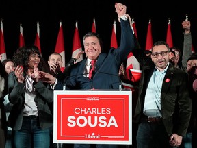 Federal cabinet ministers Iqra Khalid, left, and Omar Alghabra, right, raise hands with Liberal candidate Charles Sousa as they celebrate his byelection victory in Mississauga, Ont., on Dec. 12, 2022.