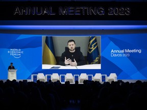 Ukrainian President Volodymyr Zelenskyy is displayed on a screen via video link at the Congress centre during the World Economic Forum (WEF) annual meeting in Davos January 18, 2023. (Photo by Fabrice COFFRINI / AFP)
