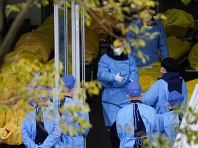 Staff members speak next to several body bags at a funeral home, as COVID-19 outbreaks continue in Shanghai, on Jan. 4.