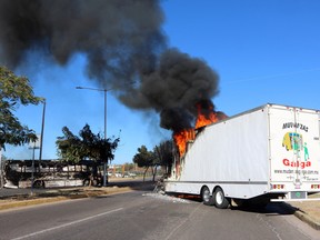 The burnt wreckage of a bus and a burning truck, set on fire by members of a drug gang are pictured following the arrest of Mexican drug gang leader Ovidio Guzman, son of incarcerated kingpin Joaquin “El Chapo” Guzman, in Culiacan, Mexico, January 5, 2023.