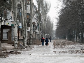 People walk through the destroyed city of Bakhmut as soldiers remain in fierce fighting to defend the city against the Russians on January 14, 2023 in Bakhmut, Ukraine.