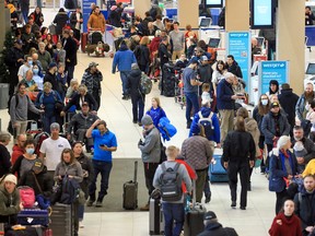 Hundreds of WestJet passengers wait to rebook canceled flights at Calgary International Airport on December 20, 2022.
