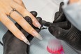 The manicurist makes nude gel polish nails for the client. The process of creating a manicure.