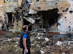 60-year-old, Andryi Pleshan, checks destruction around his shelter in the city of Izium, eastern Ukraine on January 2, 2023.