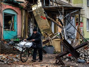 A local resident pushes his bicycle past "hedgehog" tank traps and rubble, down a street in Bakhmut, Donetsk region, on January 6, 2023, amid the Russian invasion of Ukraine. - Russia and Ukraine have both suffered heavy casualties in the fight for Bakhmut, and most of the city's pre-war population of 70,000 have left for safer territory, leaving behind cratered roads and buildings reduced to rubble and twisted metal.