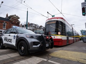 Police cars surround a TTC streetcar on Spadina Ave., in Toronto on Tuesday, January 24, 2023 after a stabbing incident.Police are expected to increase their presence on city transit following an uptick in violence incidents at subway stations across the city. THE&ampnbsp;CANADIAN PRESS/Arlyn McAdorey