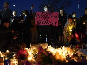 A man holds a sign during a vigil outside Monterey Park City Hall, blocks from the Star Ballroom Dance Studio, late Tuesday, Jan. 24, 2023, in Monterey Park, Calif. A gunman killed multiple people at the ballroom dance studio late Saturday amid Lunar New Year's celebrations in the predominantly Asian American community.