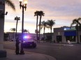 A police officer ties tape around a light pole in Monterey Park, Calif., Sunday, Jan. 22, 2023. A mass shooting took place at a dance club following a Lunar New Year celebration, setting off a manhunt for the suspect.