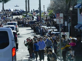 People watch as the motorcade with President Joe Biden arrives in Capitola,Calif., Thursday, Jan 19, 2023. Biden will survey recovery efforts following a series of severe storms.