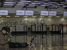 A passenger waits in an empty terminal at the airport while flights are suspended due to drug cartel-related violence in Culiacan, Sinaloa state, Mexico on January 6, 2023.