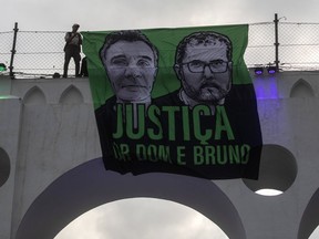 FILE - A sign that reads in Portuguese "Justice for Dom and Bruno" and with images of the British journalist Dom Phillips, on the left, and the indigenous specialist Bruno Pereira is displayed on the Arcos da Lapa aqueduct during a protest by environmental groups in Rio de Janeiro, Brazil, June 26, 2022. Brazilian police said Monday, Jan. 23, 2023, they planned to indict Ruben Dario da Silva Villar, a Colombian fish trader, as the mastermind of murders.