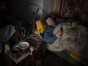 Suffering from cancer, Gennadiy Shaposhnikov, 83, rests in his partially destroyed home which was hit by Russian shelling last fall in Kalynivske, Ukraine, Saturday, Jan. 28, 2023.