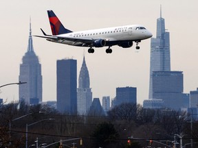 A Delta Airlines jet comes in for a landing in front of the Manhattan skyline after flights earlier were grounded during an FAA system outage, at Laguardia Airport in New York City, January 11, 2023.